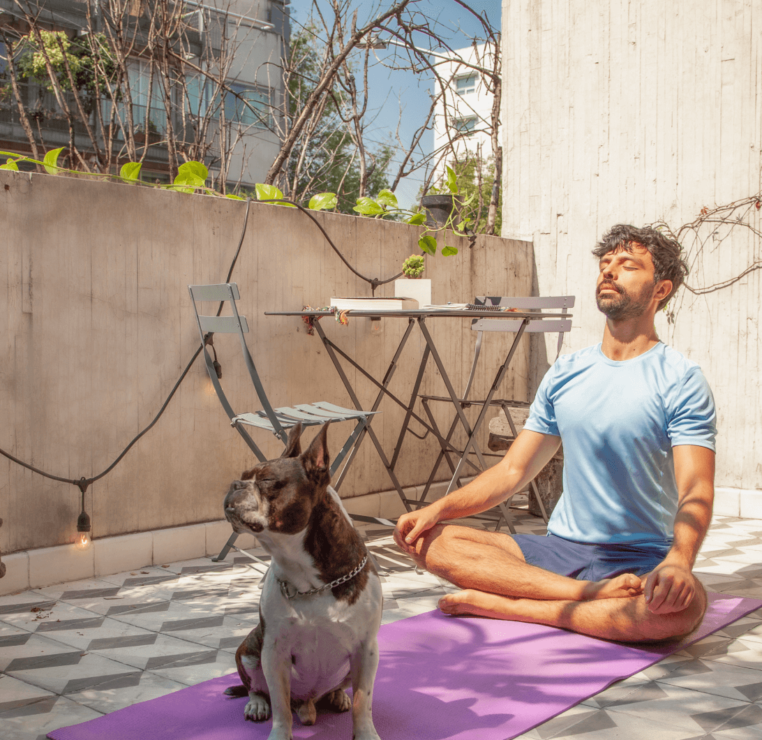 Foto de un hombre practicando yoga con su perro.